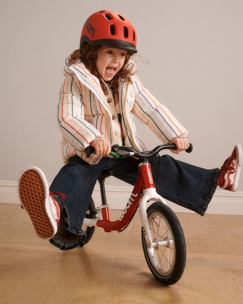 A girl riding a balance bike.