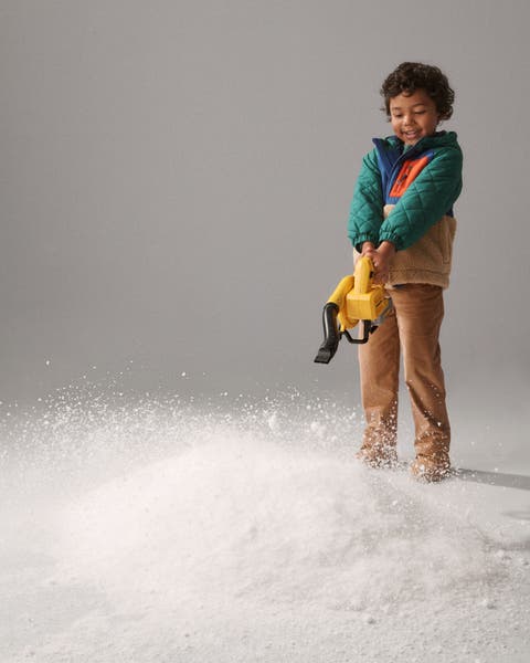 A boy with a toy leaf blower.