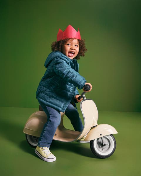 A little girl on a scooter.