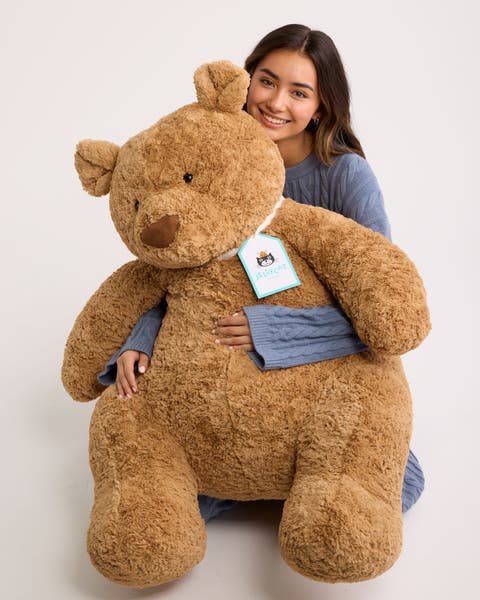 A woman holding a large stuffed bear.