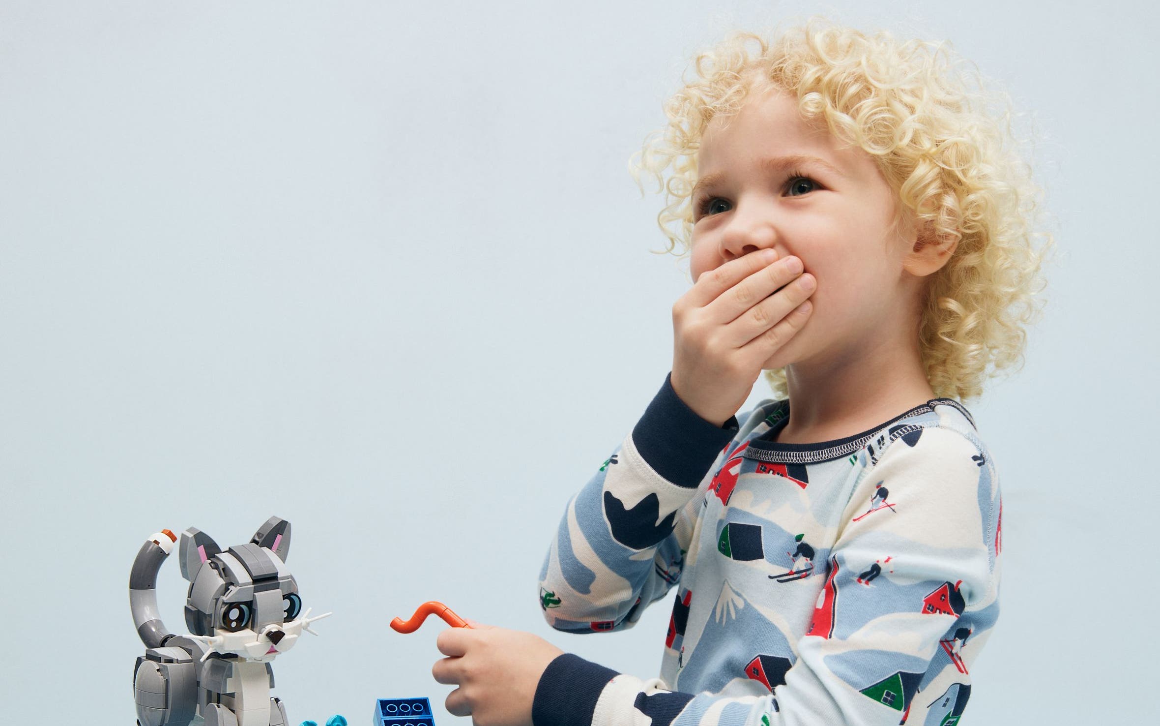 A child building a Lego cat.