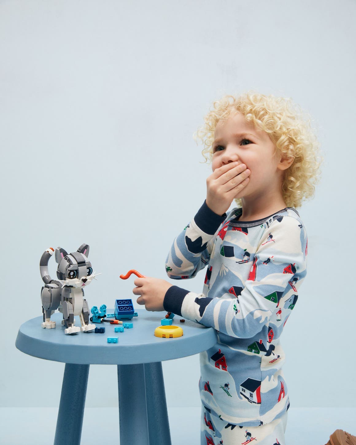 A child building a Lego cat.