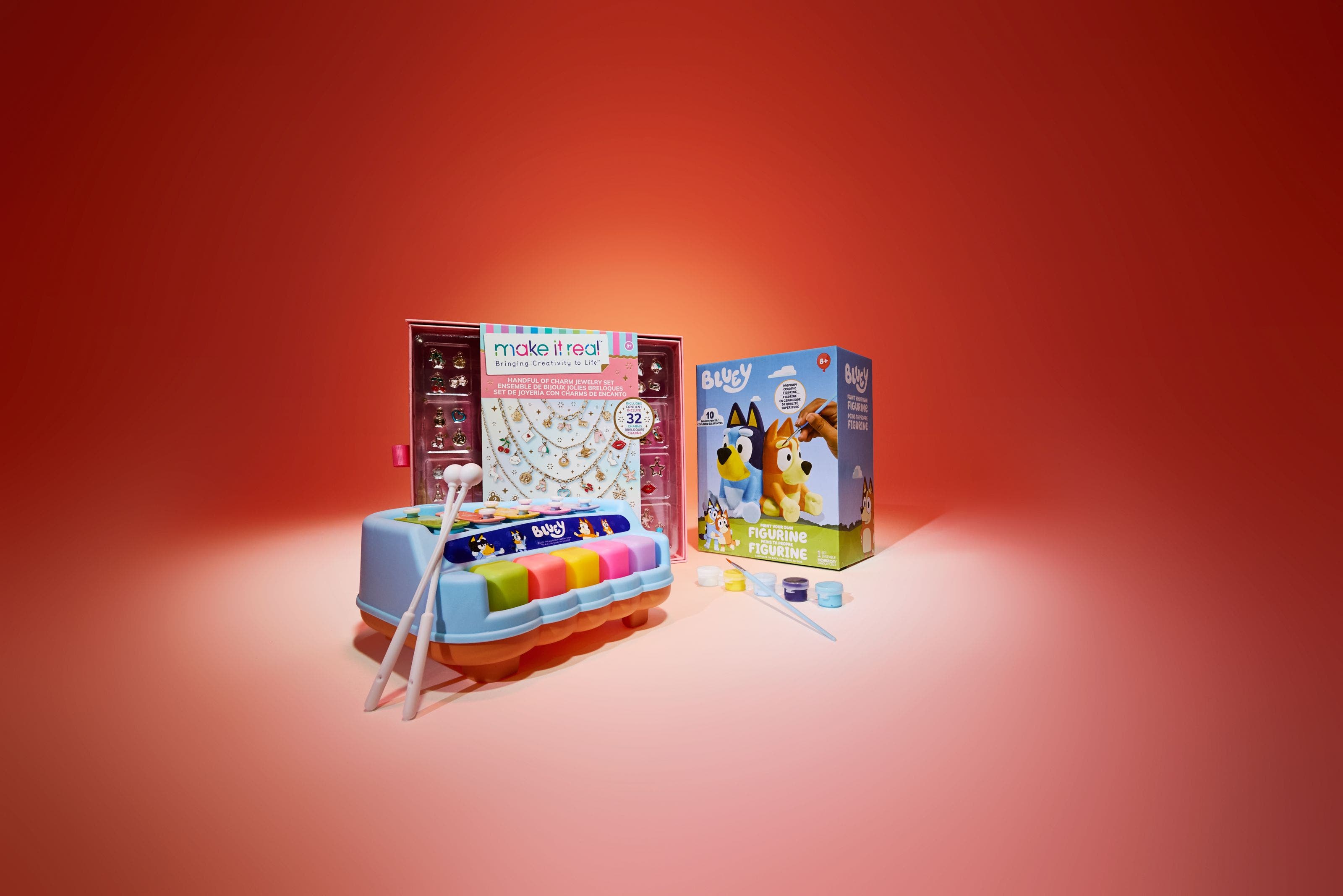 Children's gift set featuring a Make It Real charm jewelry kit, a Bluey xylophone, and a Bluey paint-your-own figurine set.