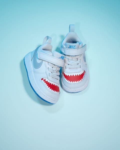 Nike infant sneakers in light blue with shark teeth graphic detail.