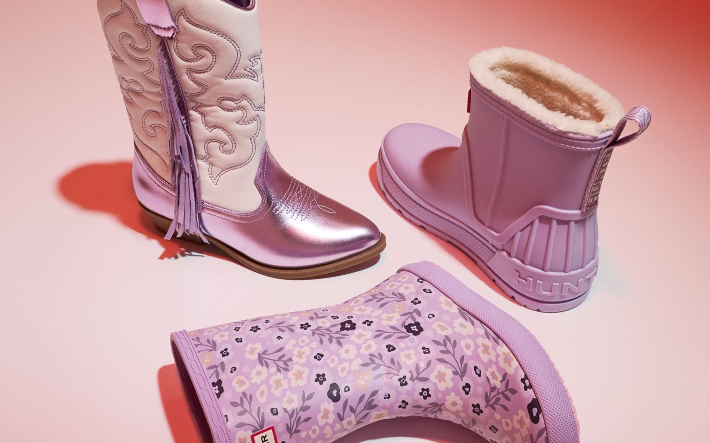 An assortment of pink-colored kids’ boots. 