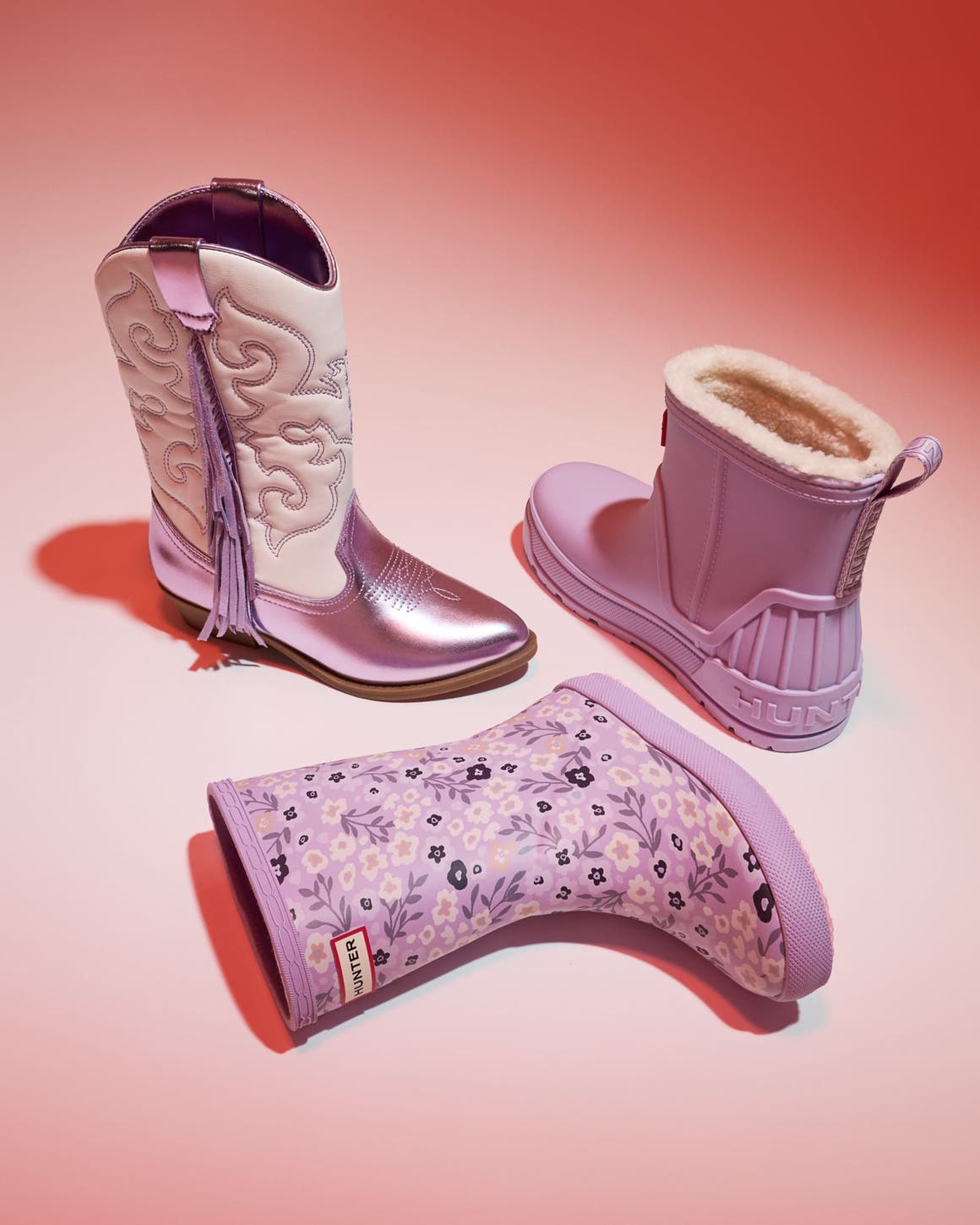 An assortment of pink-colored kids’ boots. 