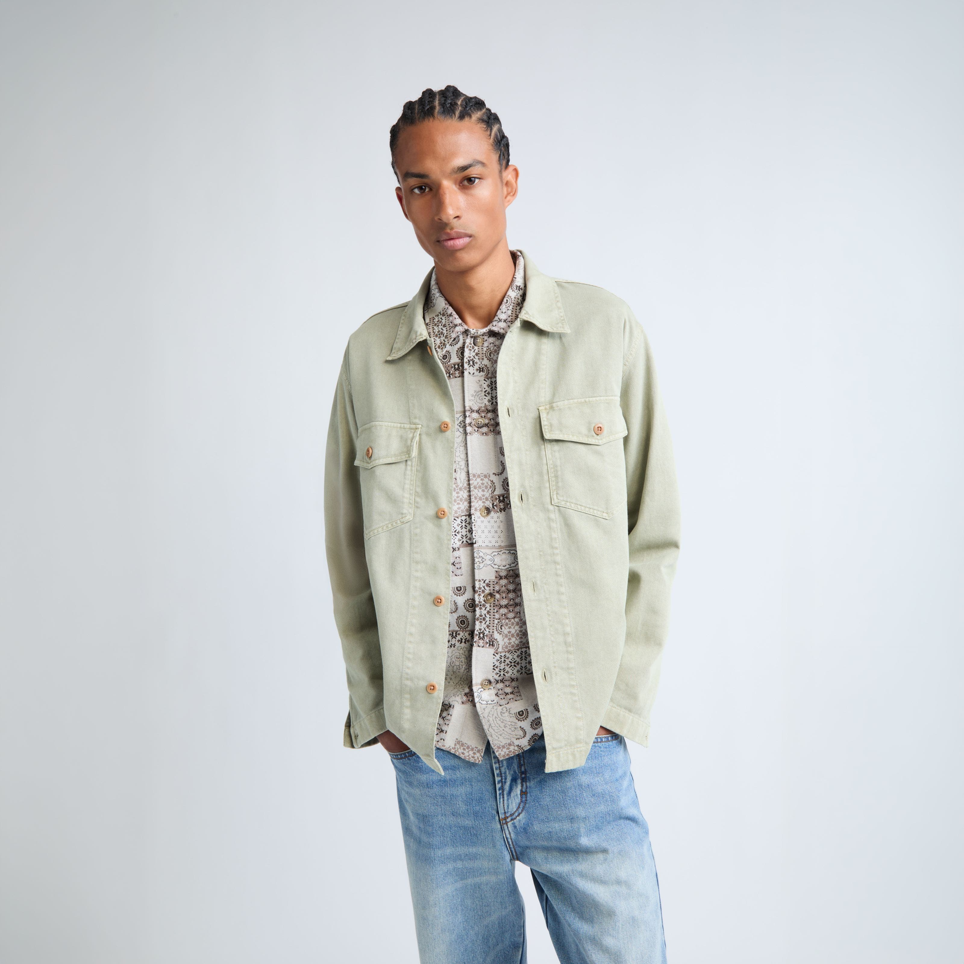 A mean wearing shirt jacket, shirt, and denim pants.