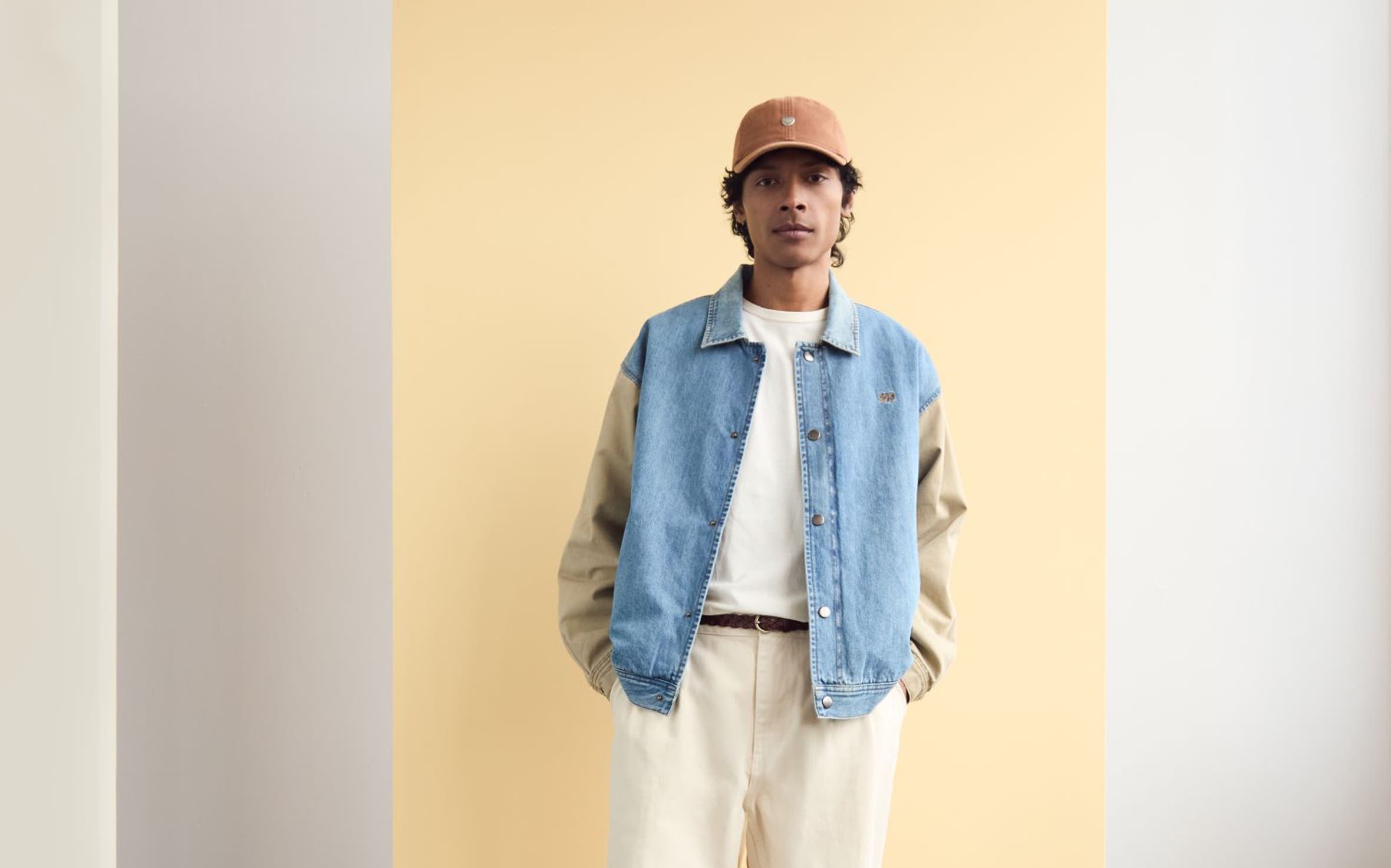 Man wearing a cap, jacket, T-shirt, white denim and boots.