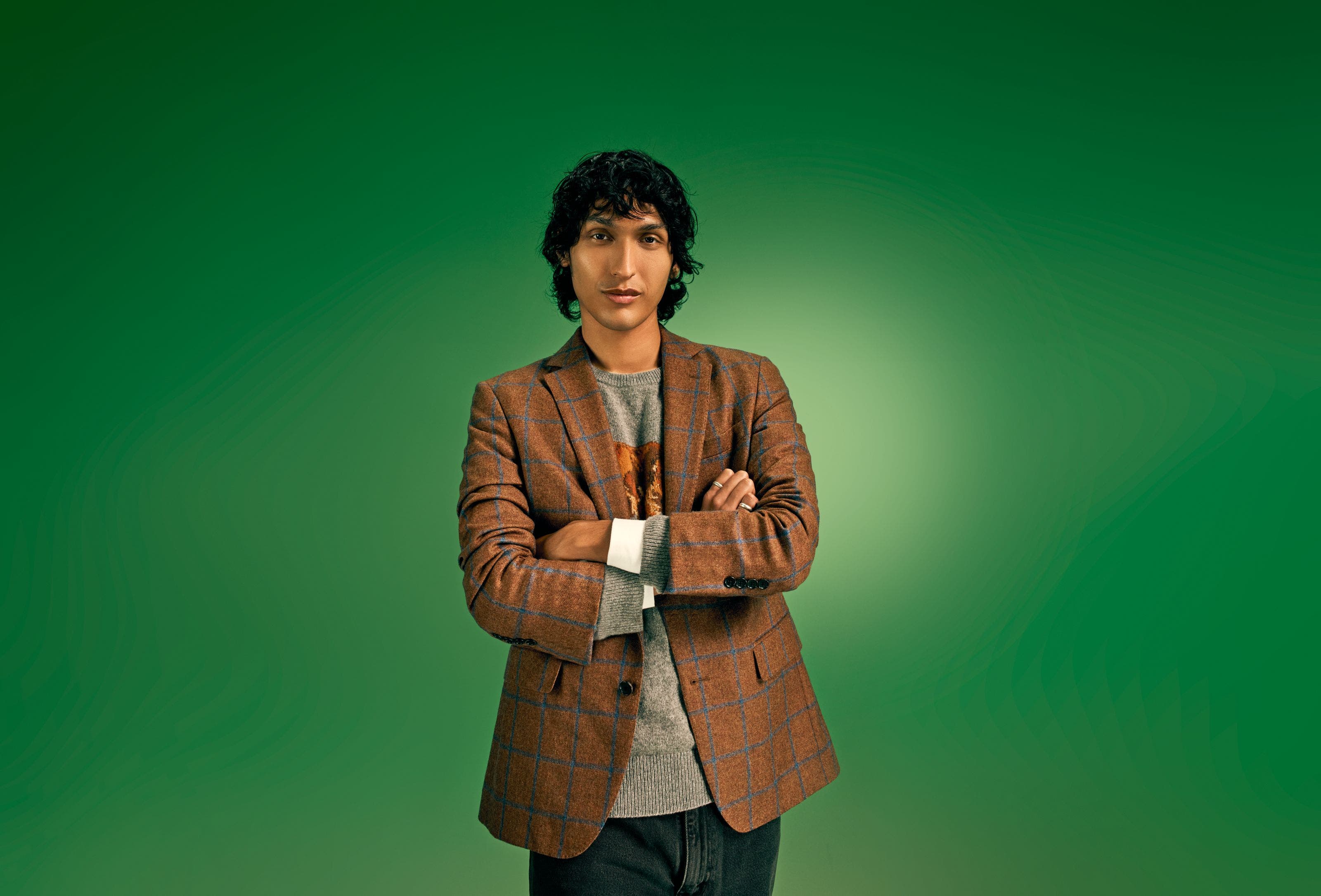 A man wearing a blazer over a sweater.
