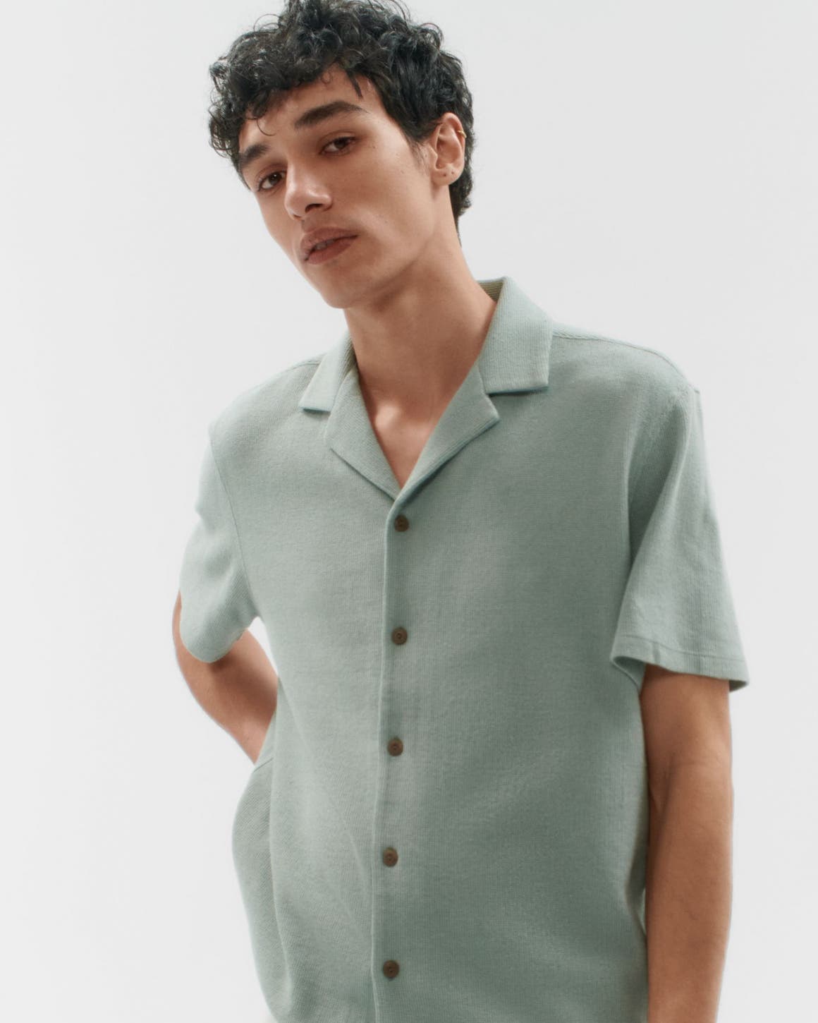 A man wearing a short-sleeve button-up shirt.