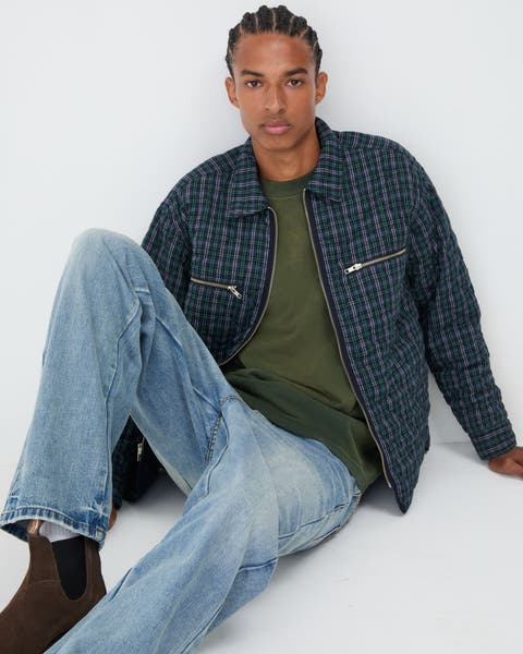 Man wearing a shirt jacket, jeans and boots.