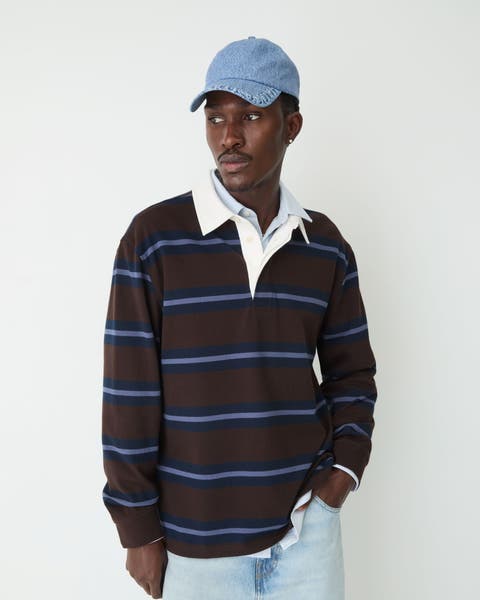A man wearing striped polo with cap.