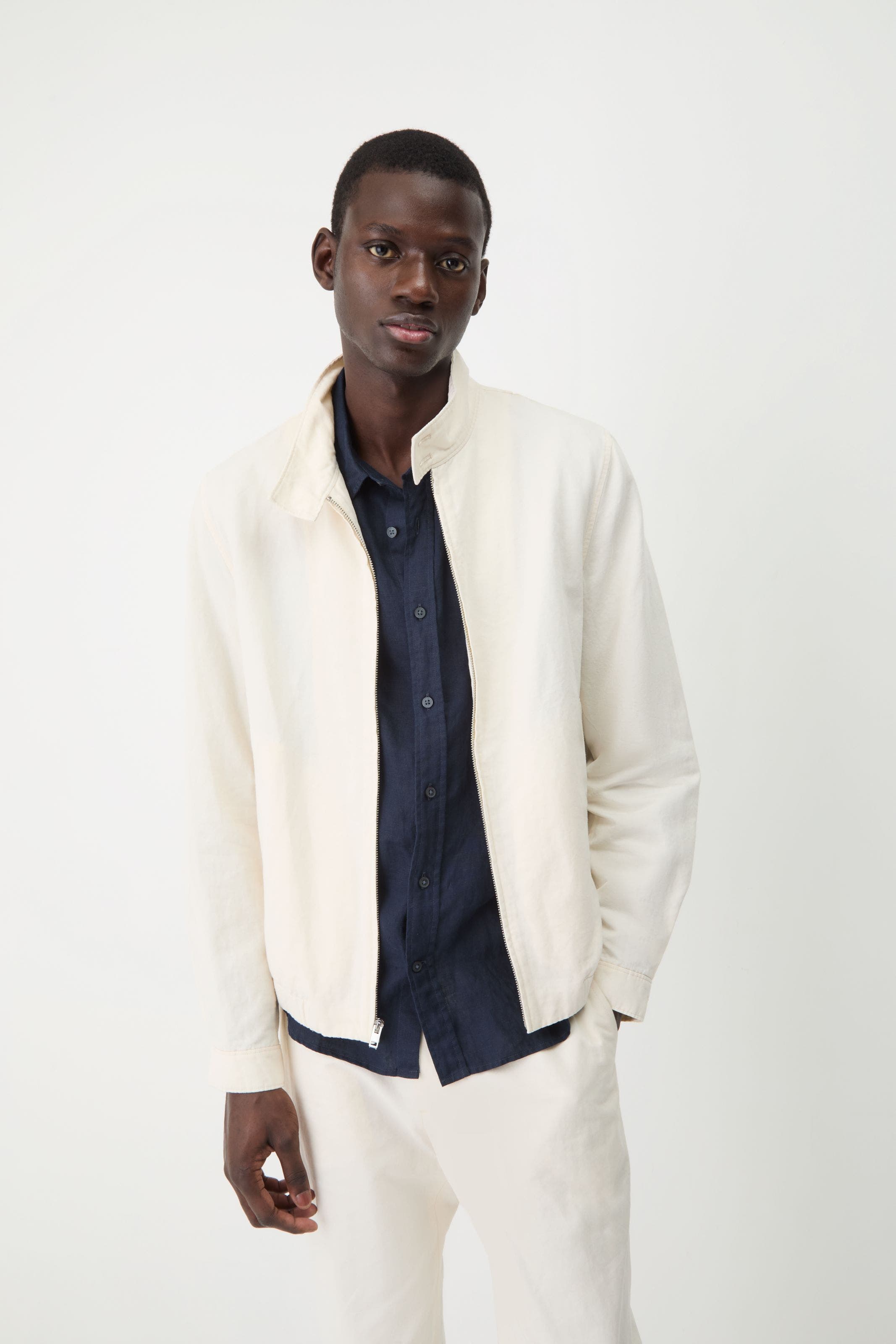 Man wearing a white lightweight jacket.