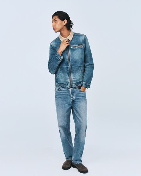 Man wearing denim jacket, denim jeans and boots.