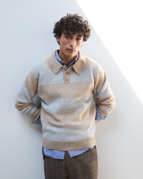 A man wearing striped a sweater polo.