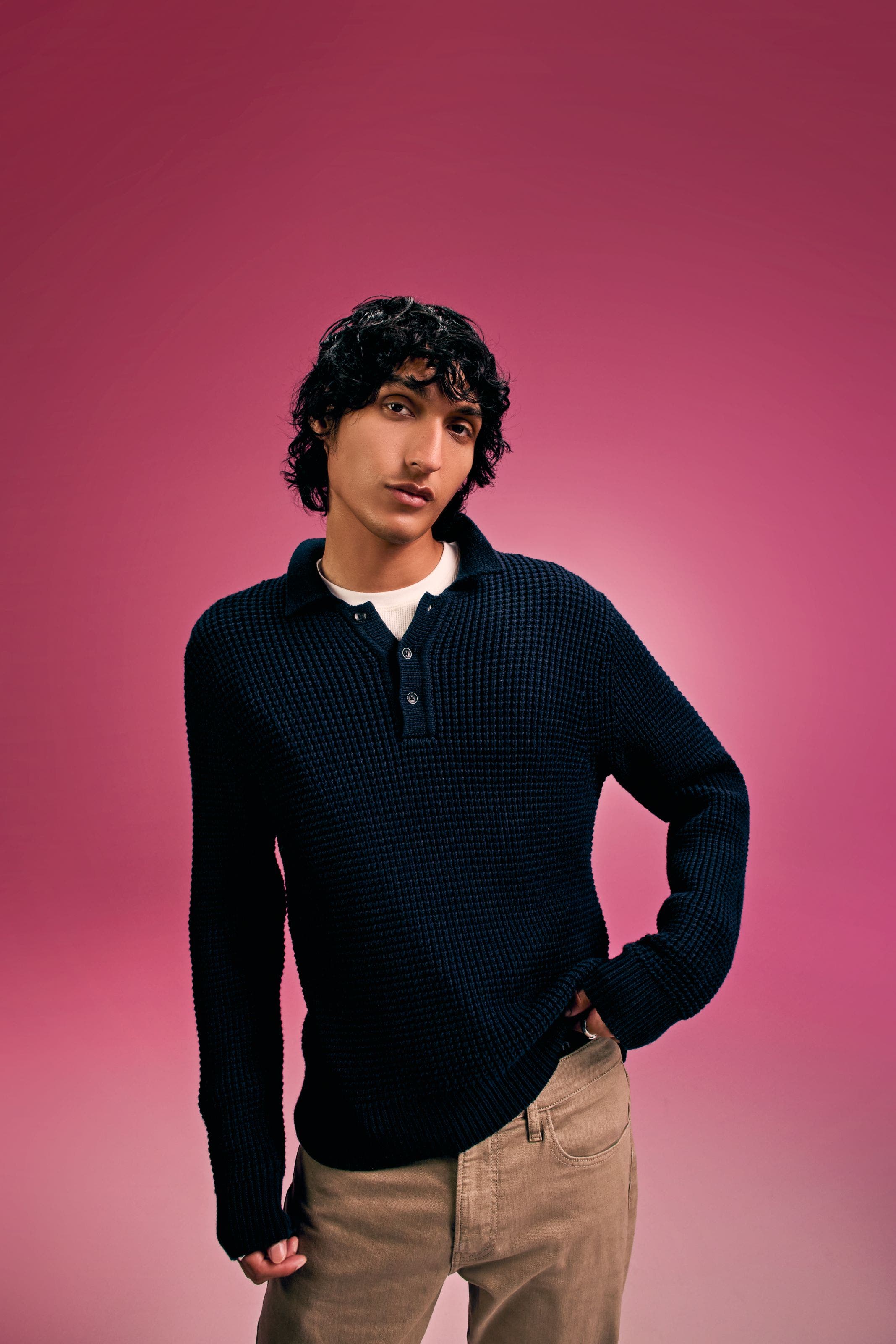 A man wearing a sweater and slacks.