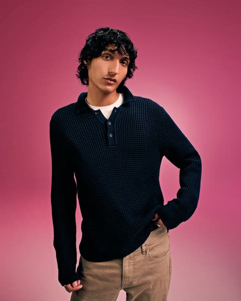 A man wearing a sweater and slacks.