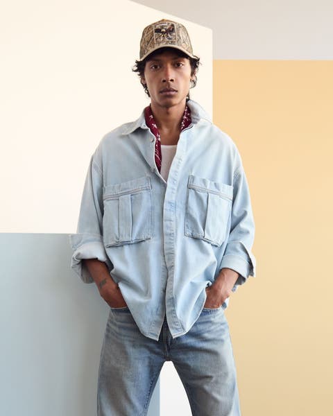 A man wearing a light denim shirt jacket.