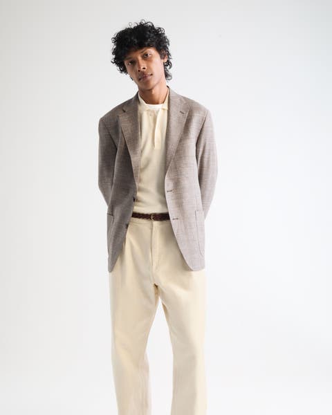 A man wearing pants with t-shirt, sportscoat.