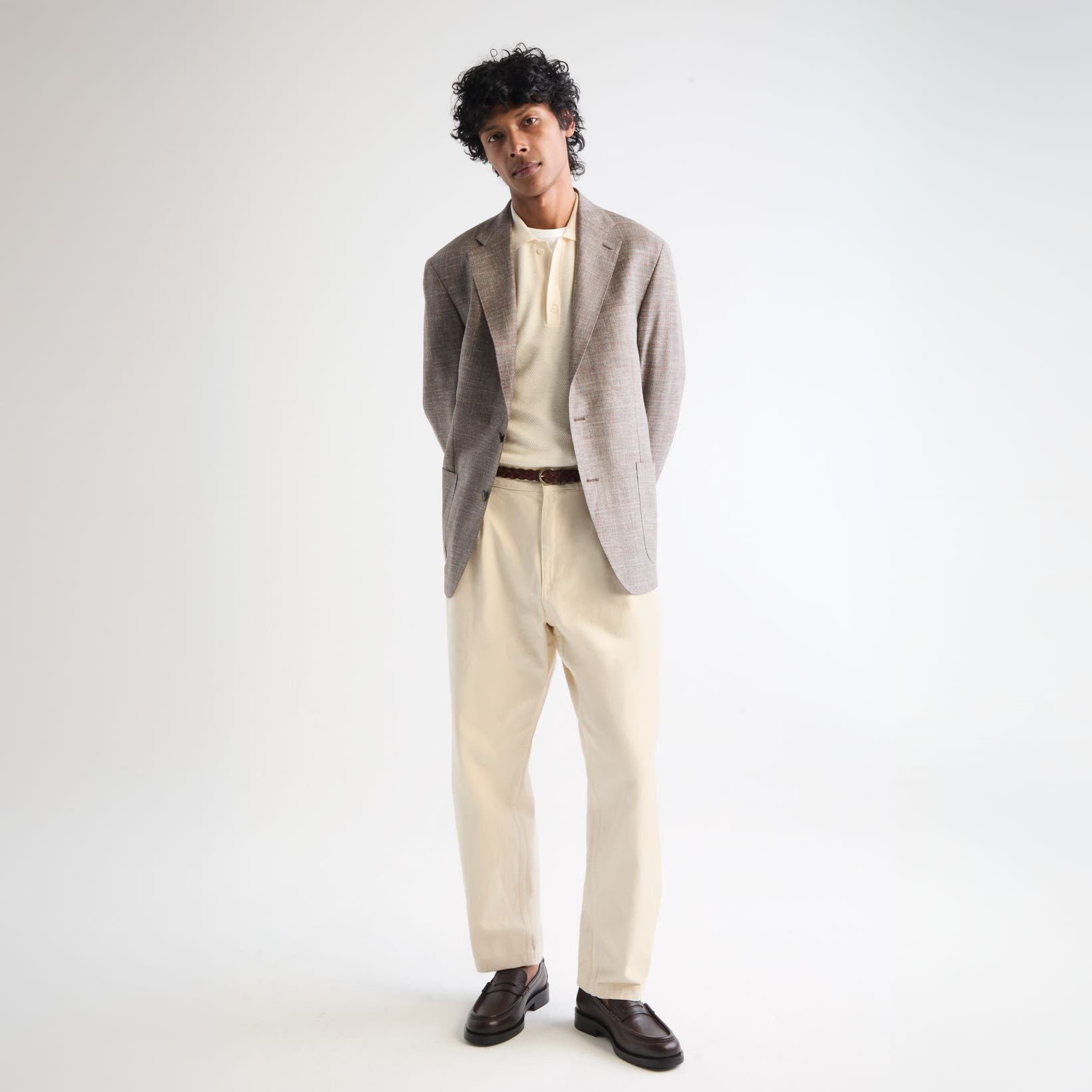 Man wearing a blazer, shirt, trousers and loafers.