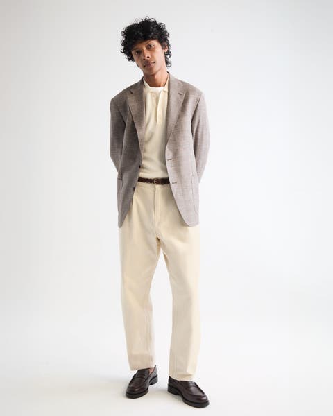 A man wearing khaki pants and t-shirt with sportscoat.