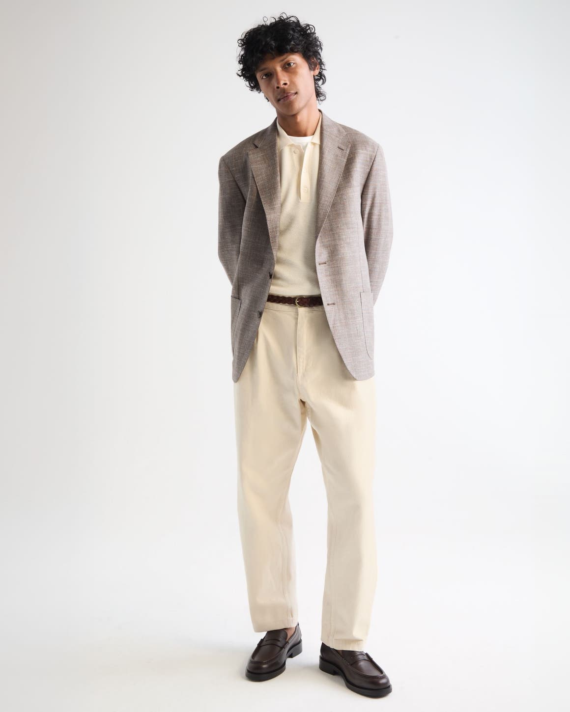 Man wearing a blazer, polo shirt, trousers, belt and loafers.