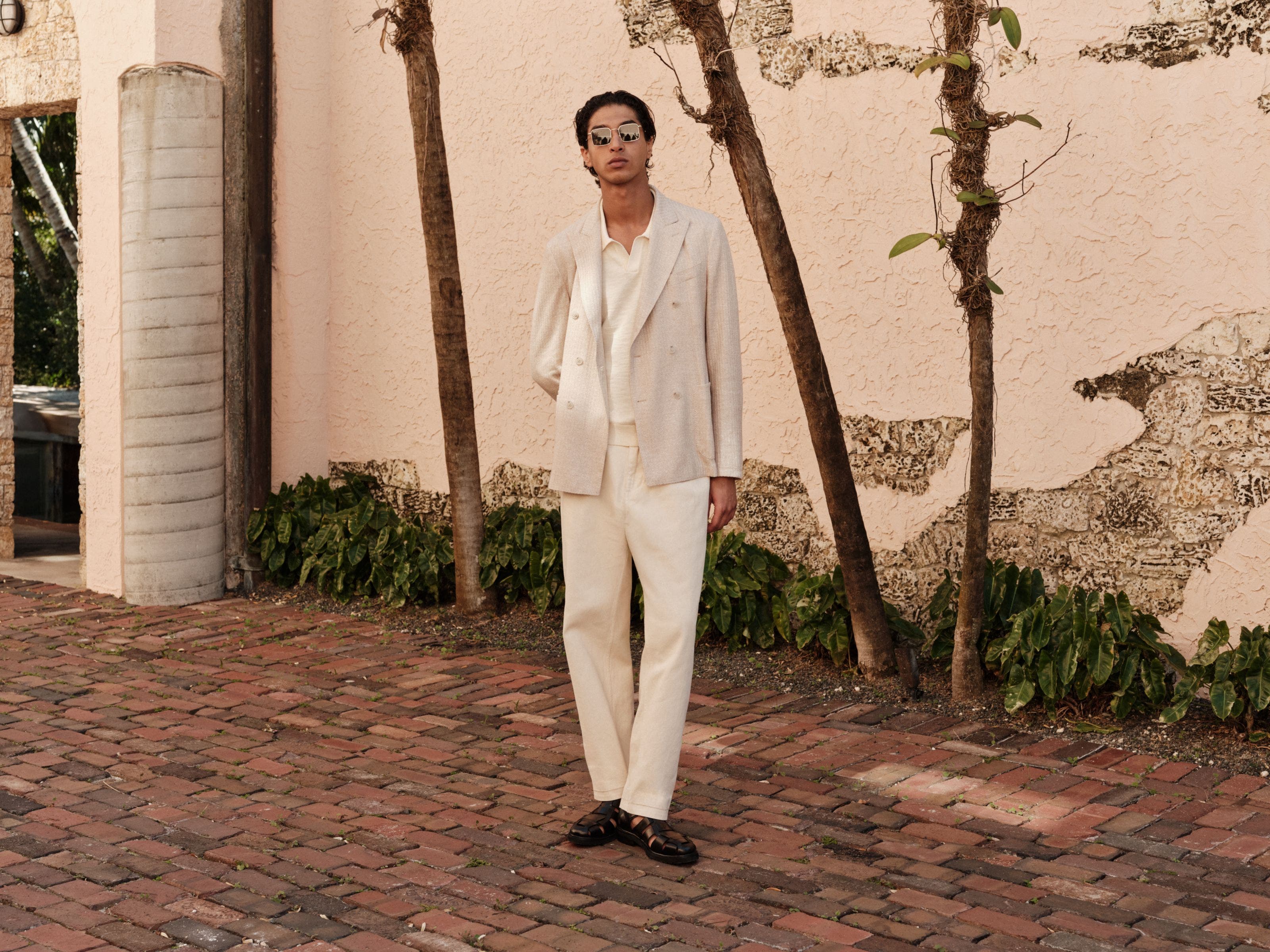 Man wearing a cream double-breasted blazer, wide-leg trousers and fisherman sandals.
