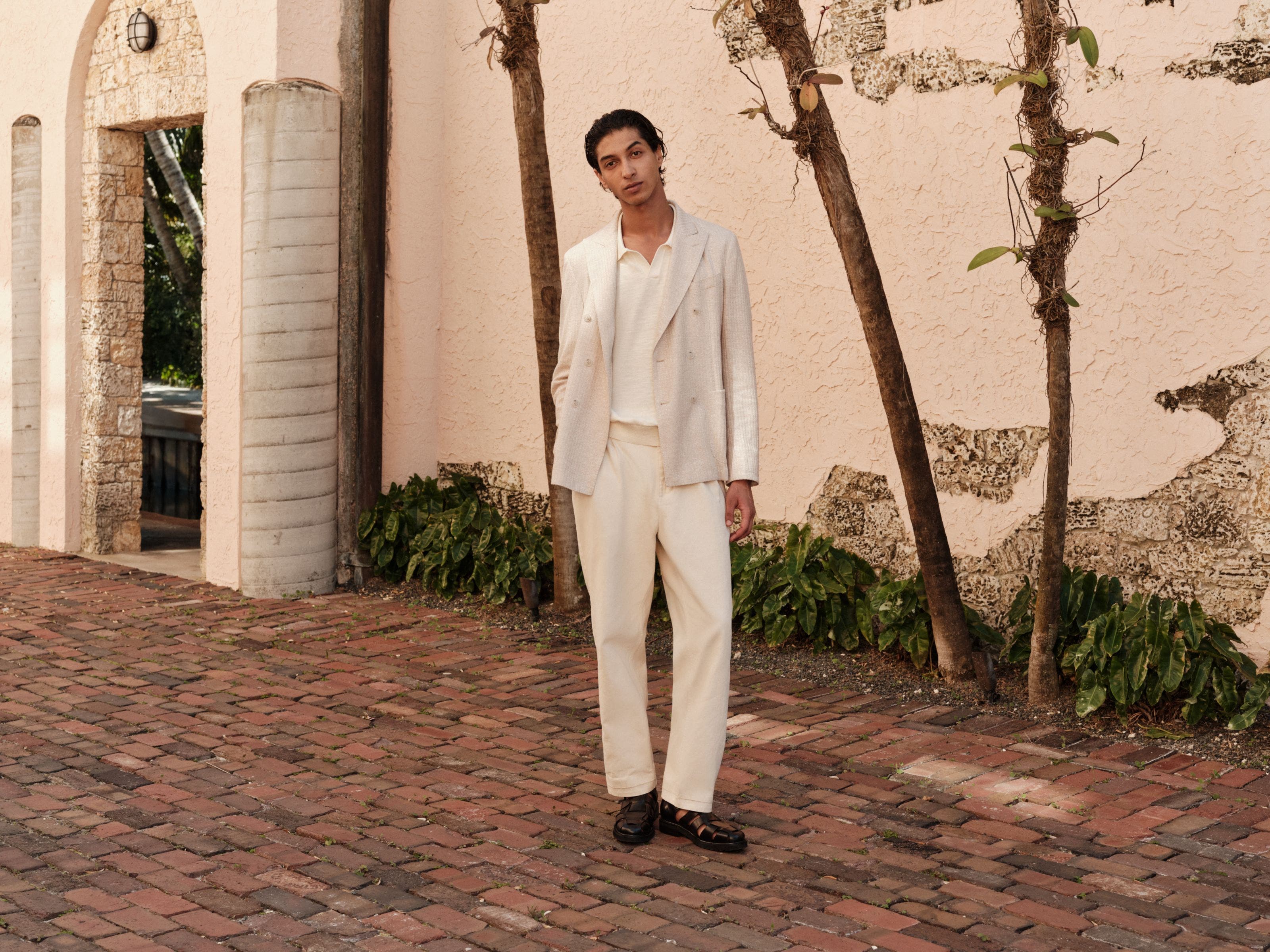 Man wearing a double-breasted linen jacket over a collared knit shirt.