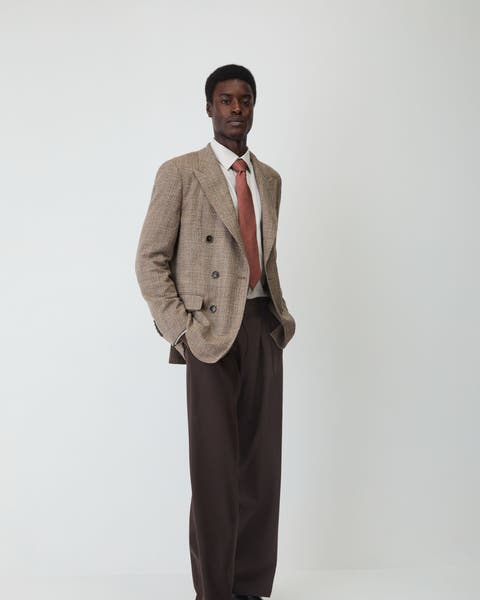 A man wearing sports coat, tie, dress shirt, and slacks.