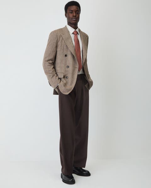 A man wearing blazer, dress pants, button up, tie and shoes.