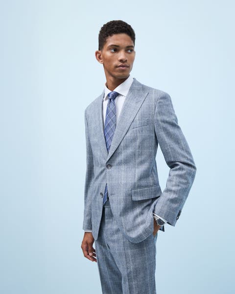 Man wearing a plaid suit with a white shirt and plaid tie.