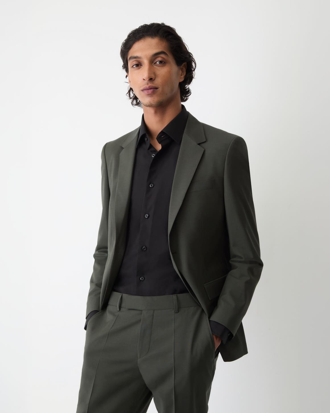 A man wearing suit and black dress shirt.