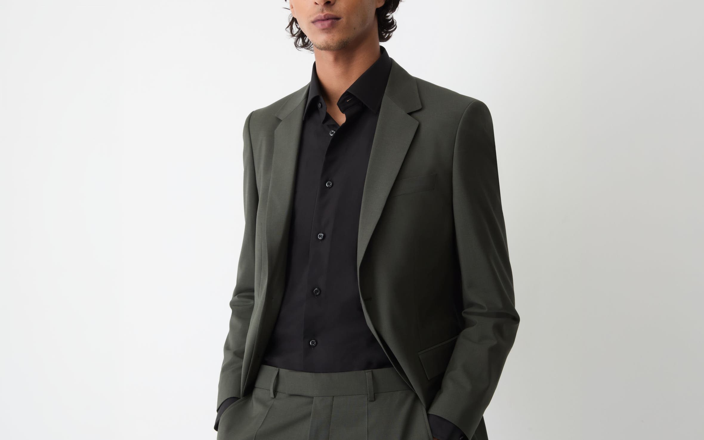 A man wearing suit and black dress shirt.