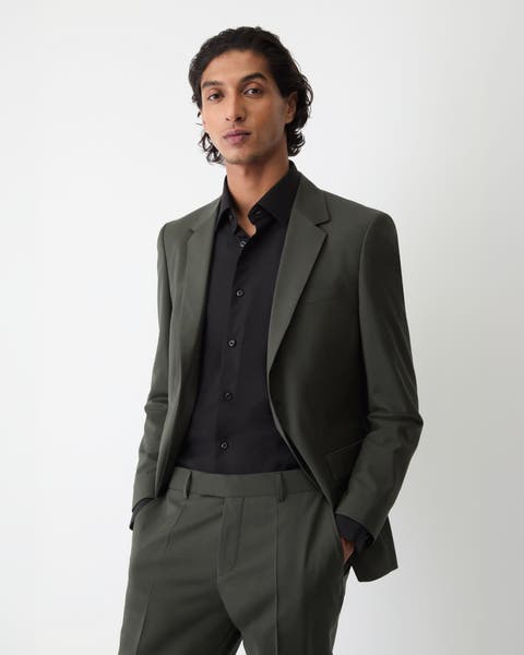 A man wearing grey suit with black dress shirt.