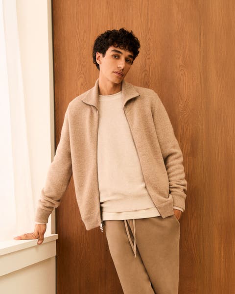 Man wearing a full-zip sweater, crewneck and sweatpants.