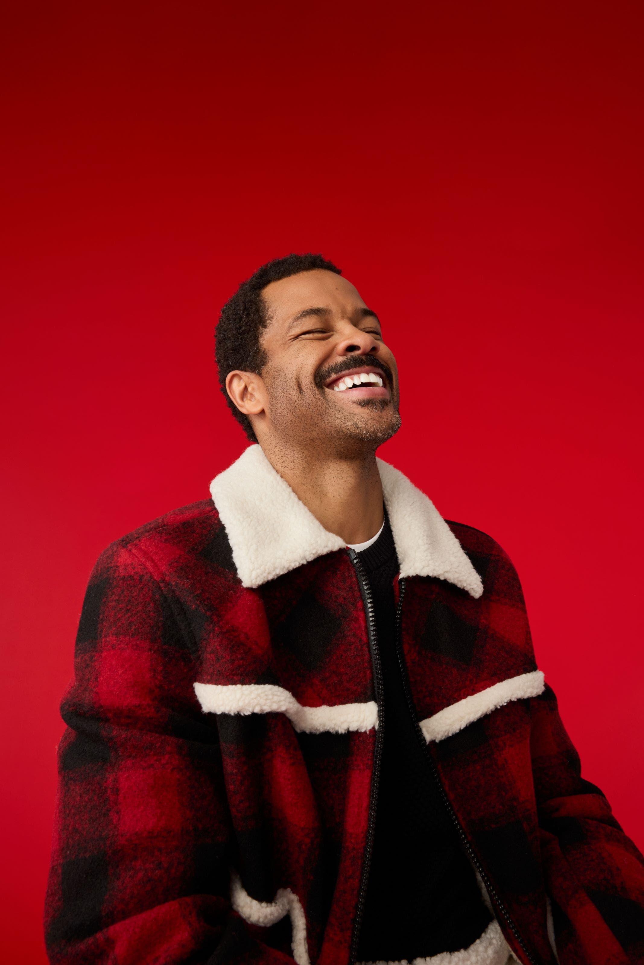 A man wearing a plaid jacket. 