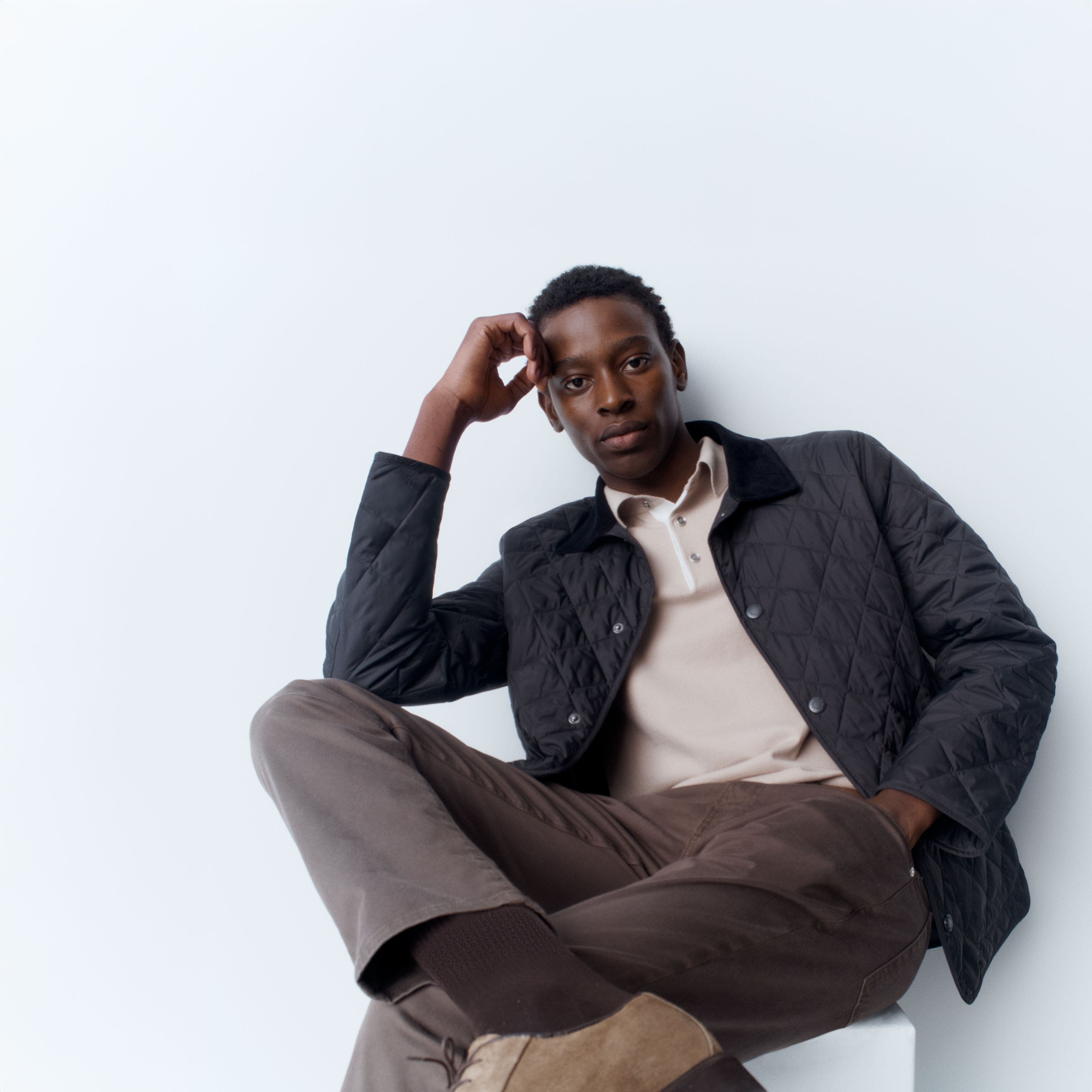 A man wearing a Barbour jacket with a Reiss polo, FRAME twill pants, BOSS belt and Bruno Magli shoes. 