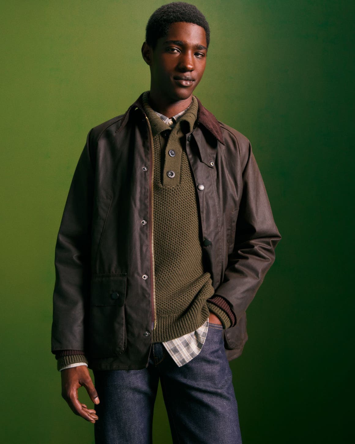 Man wearing a jacket, sweater, flannel shirt and jeans.