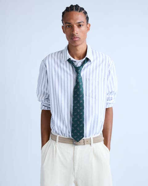 Man wearing a striped shirt with a green tie.