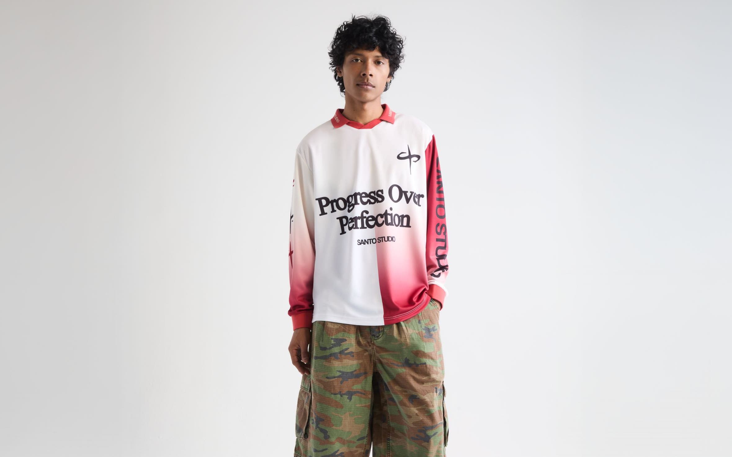 Man wearing a long-sleeve jersey, camo shorts and sneakers.