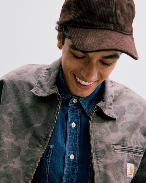 A man looking down wearing a hat. 