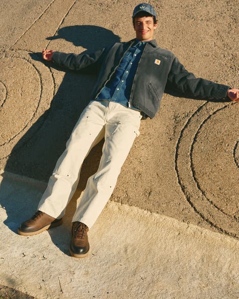 Man wearing a workwear jacket, denim shirt, carpenter jeans and boots.