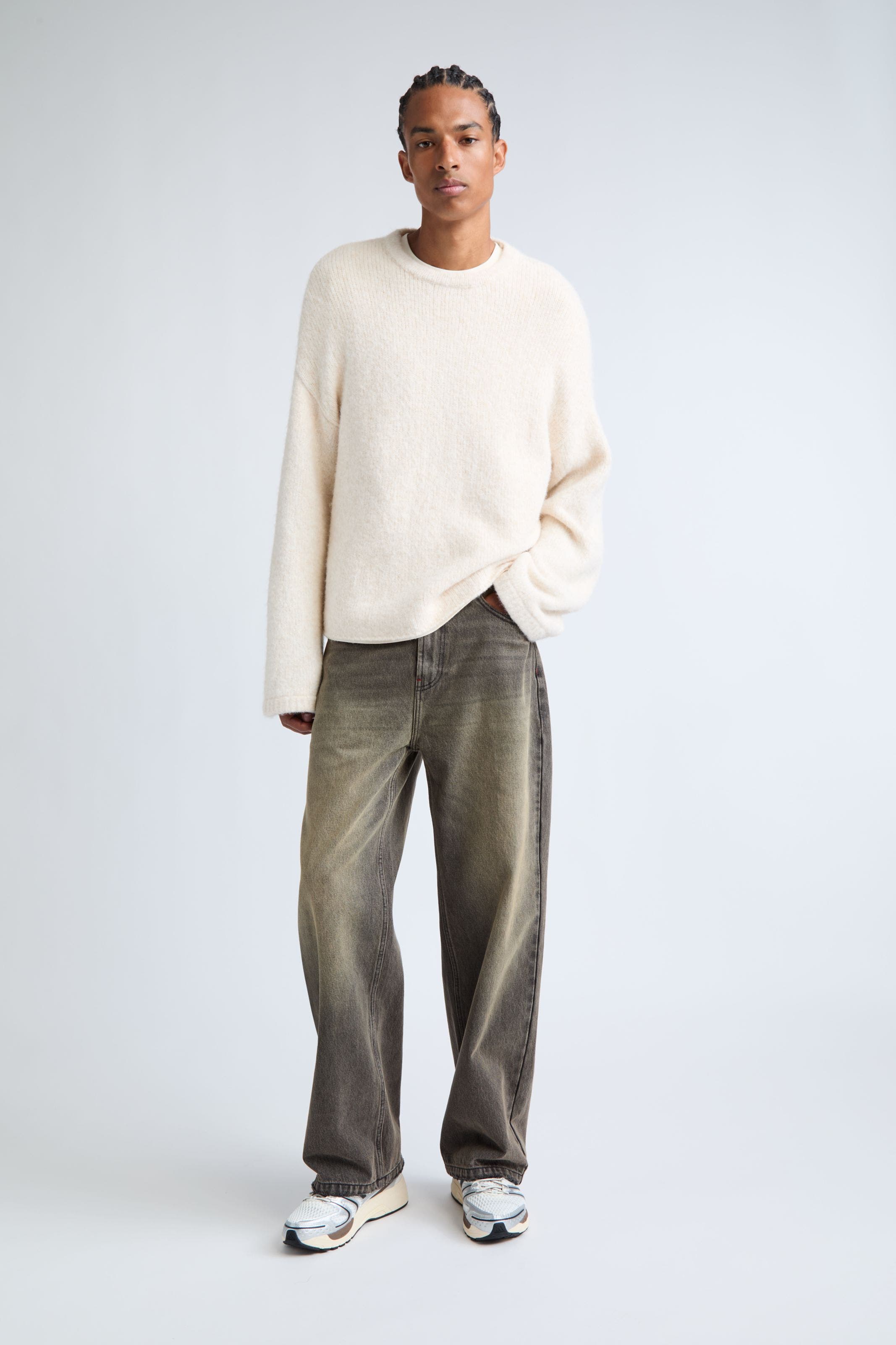 A man wearing a white crewneck sweater.