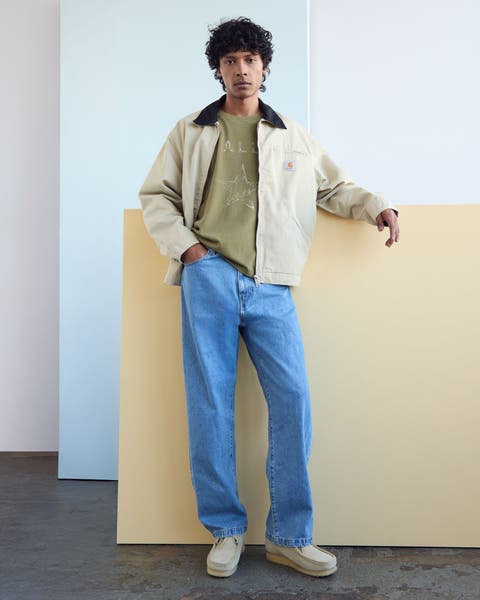 Man wearing Carhartt detroit jacket and jeans.