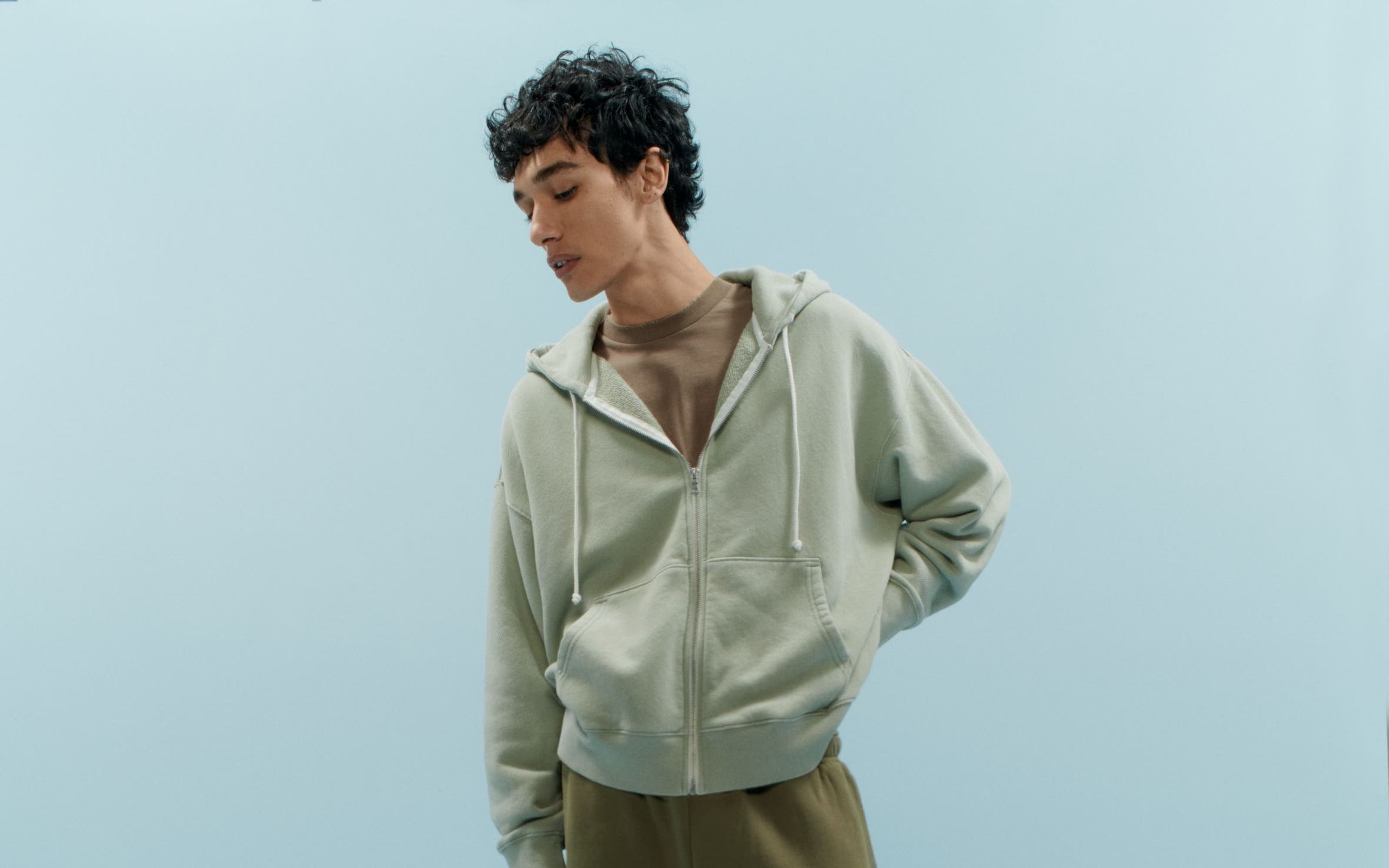 A man wearing an Elwood zip hoodie with sweat shorts, a T-shirt, crew socks and UGG slippers.