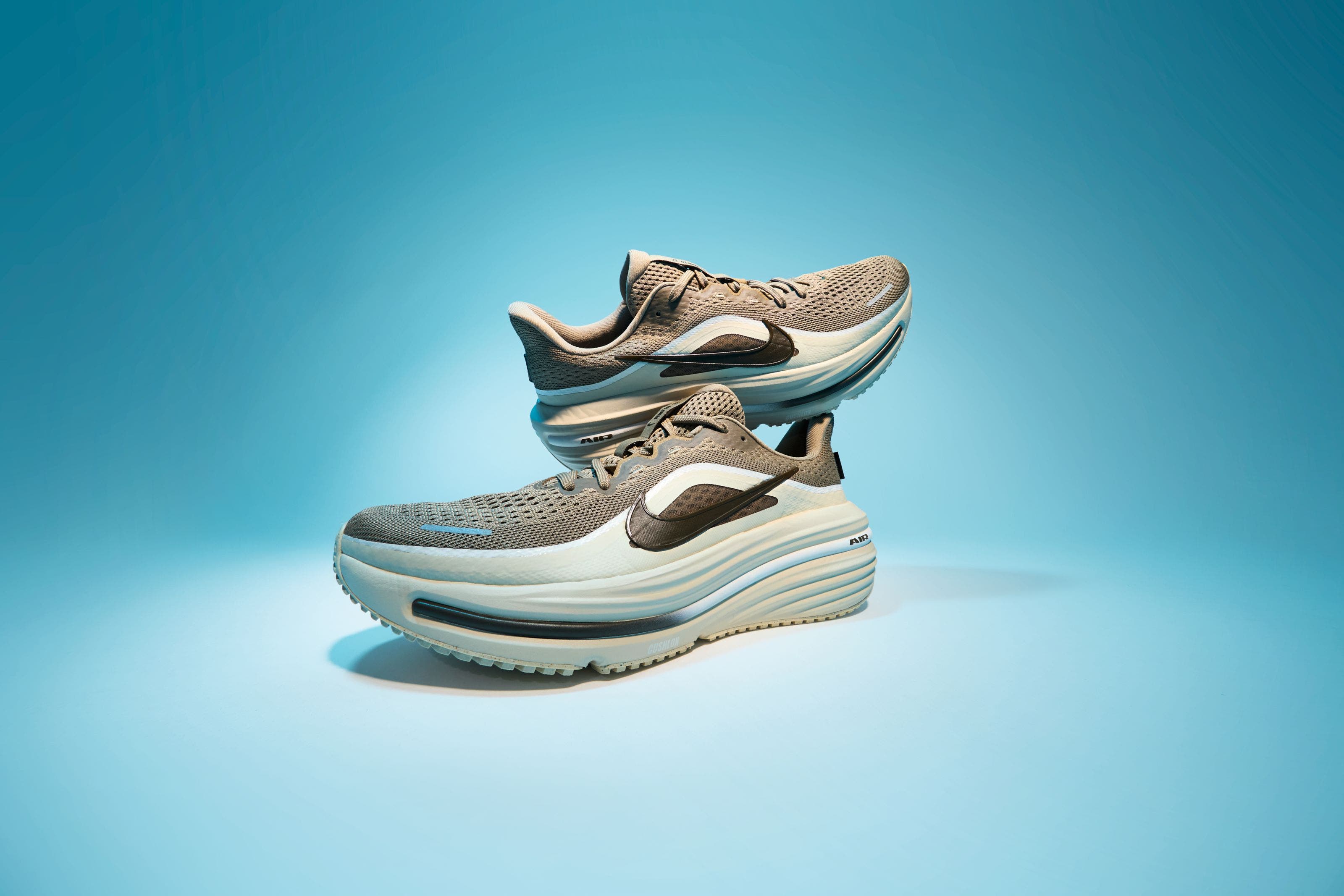 A pair of beige and gray running shoes.