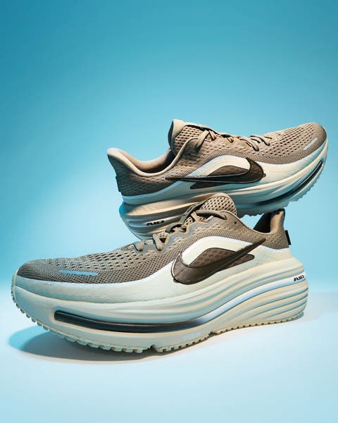 A pair of beige and gray running shoes.