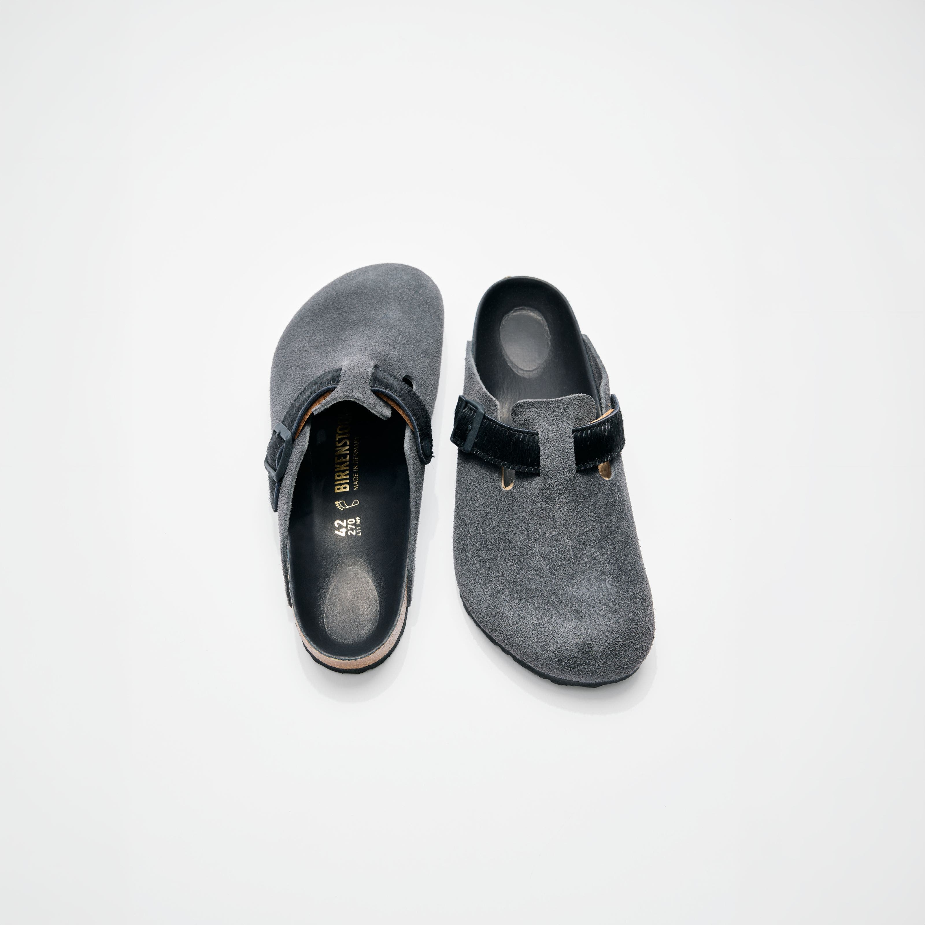 A pair of grey birkenstock slip on clogs.