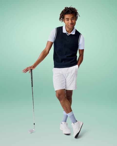A man models a golf outfit.