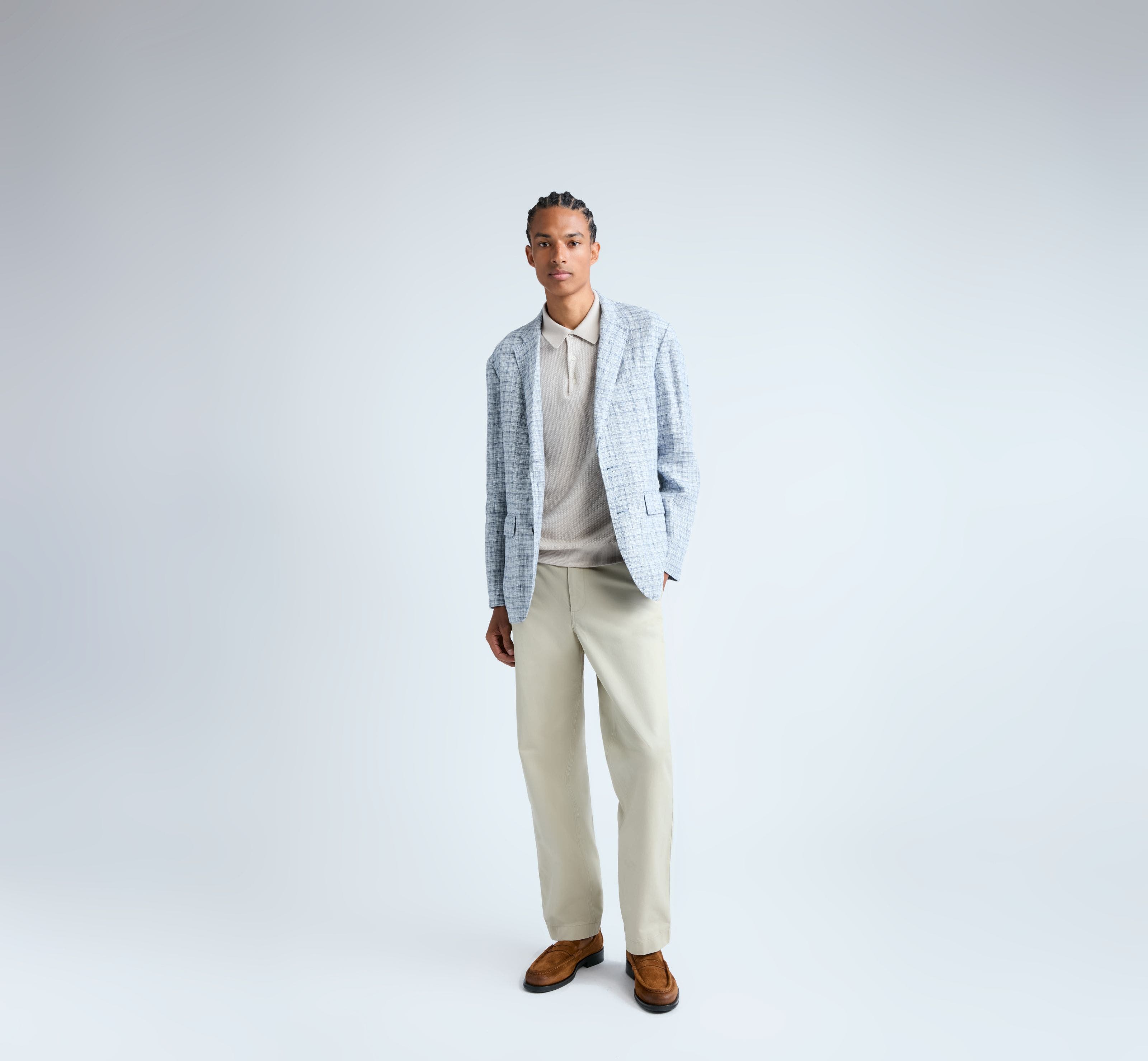 Man wearing a plaid blazer, knit polo, pants and loafers.